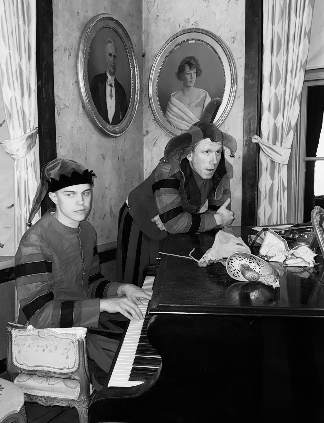 Hugo and Erik in costume beside a grand piano